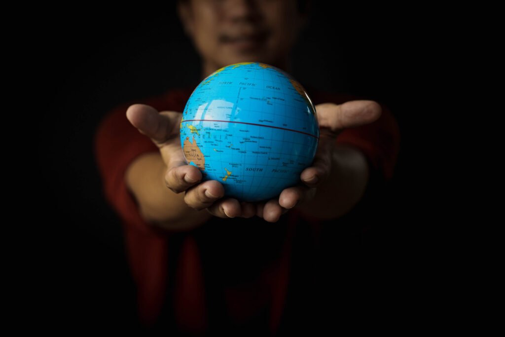 Mãos segurando um globo terrestre, representando a conexão com os sons misteriosos do hum global.