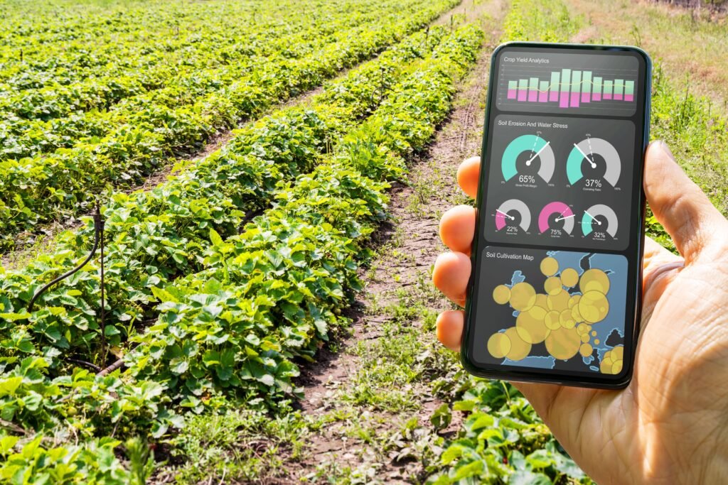 Monitoramento de dados agrícolas em smartphone, mostrando análises de produtividade, erosão do solo e mapa de cultivo em um campo de plantações verdes.