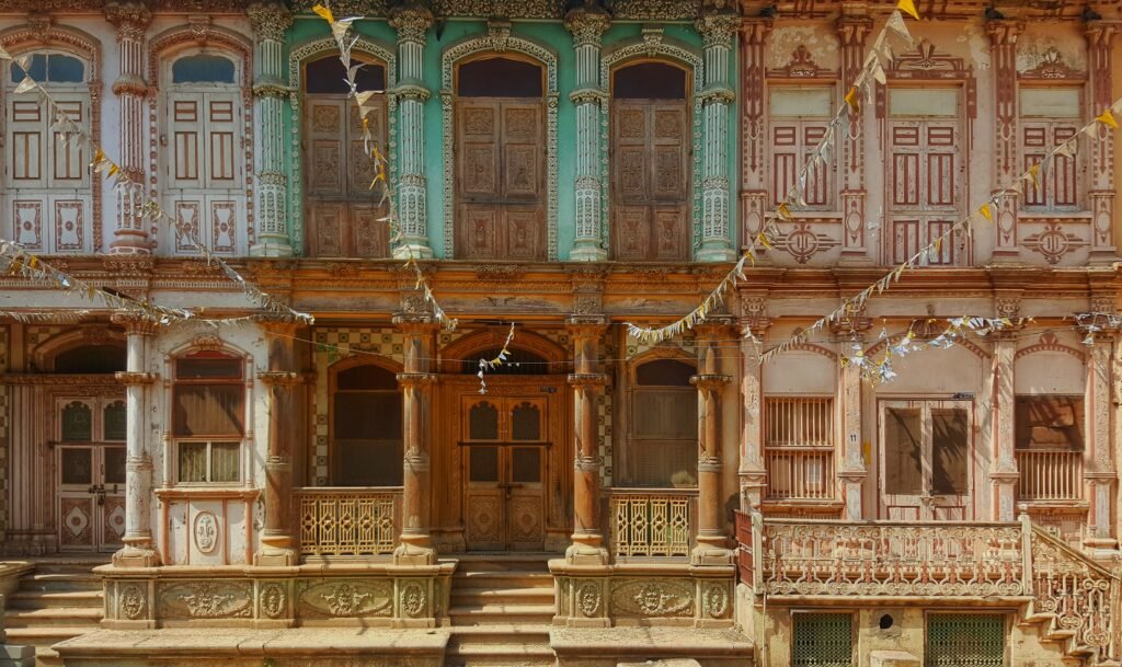 Fachada de um edifício tradicional persa com detalhes arquitetônicos ornamentados, colunas decoradas e janelas antigas.